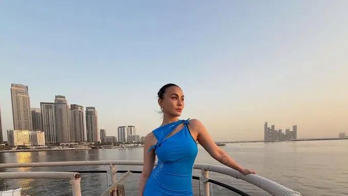 Agnez Mo Tampil Stunning dengan Gaun Cut Out Biru Muda saat Menikmati Sunset di Dubai
