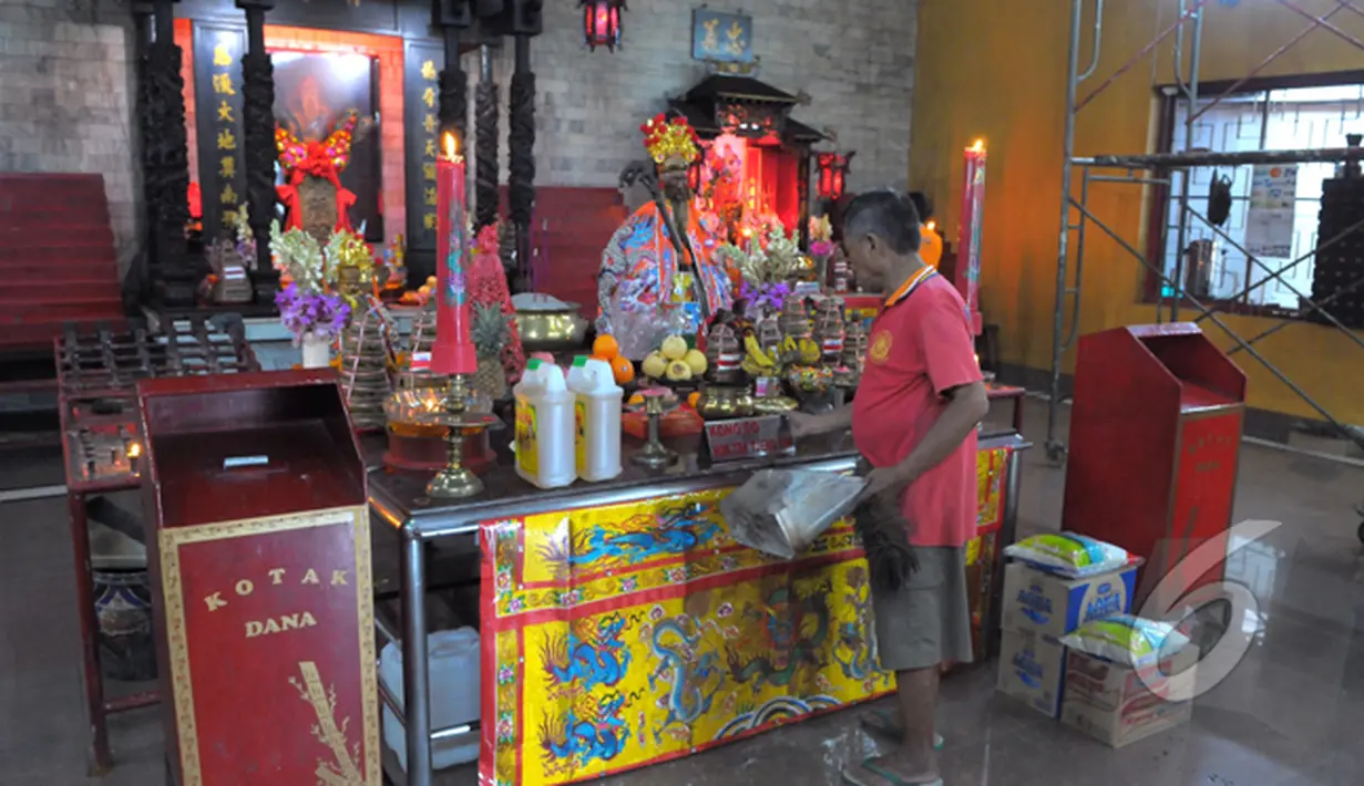 Seorang petugas tampak membersihkan meja di Vihara Amurva Bhumi, Jakarta, Sabtu (14/02/2015). Menjelang imlek sejumlah kelenteng mulai dipercantik (Liputan6.com/Andrian M Tunay)