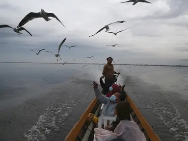 Pengunjung memberi makan burung camar di Danau Innlay yang terkenal di negara bagian Shan selatan, Myanmar, Sabtu (15/1/2022). Danau ini merupakan danau terbesar kedua di Myanmar dengan luas mencapai 116,3 kilometer persegi. (AP Photo)