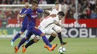 Pemain Barcelona, Paulinho Bezerra (kiri) mencoba melewati adangan pemain Sevilla, Banega pada laga La Liga Santander di Sanchez Pizjuan stadium, (31/3/2018). Barcelona bermain imbang 2-2 dengan Sevilla. (AP/Miguel Morenatti)