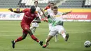 Pemain Bayer Leverkusen, Moussa Diaby, melepaskan tendangan ke gawang Borussia Moenchengladbach pada laga Bundesliga, Minggu (24/5/2020). Bayer Leverkusen menang 3-1 atas Borussia Moenchengladbach. (AFP/Ina Fassbender)