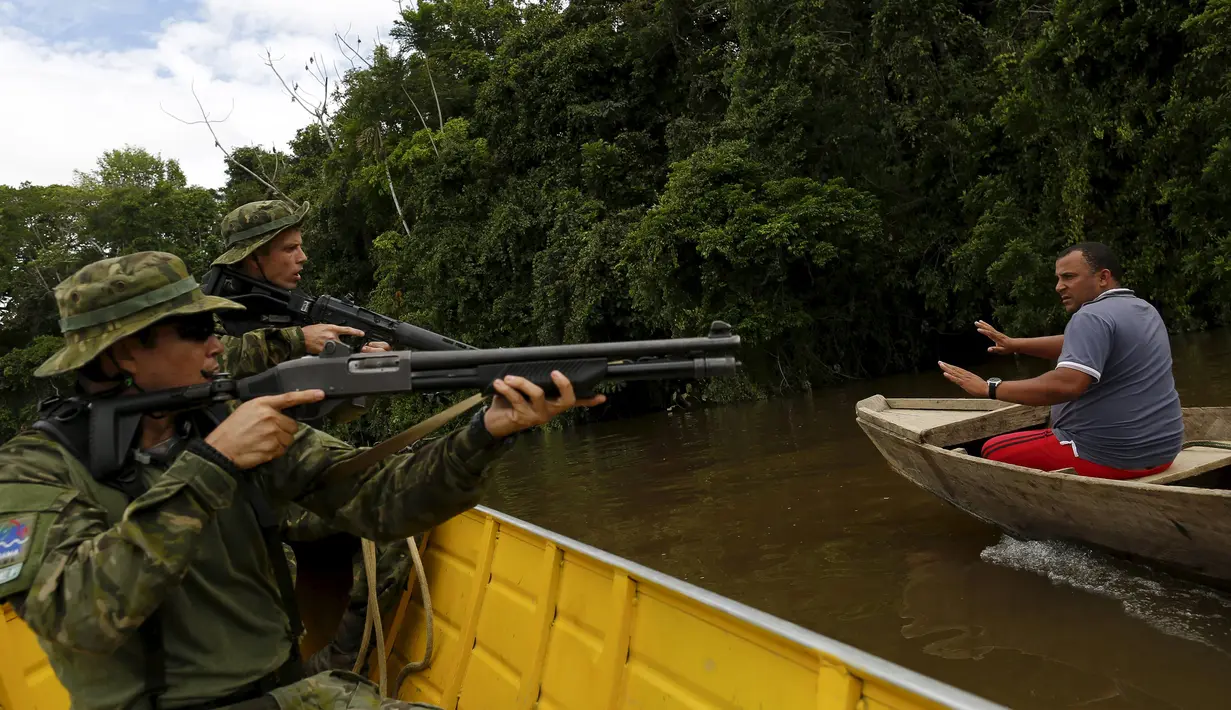 Seorang penambang liar ditangkap oleh petugas operasi di perairan hutan hujan Amazon, Roraima, Brasil (16/4). Meski telah dilarang, masih banyak penambang liar yang menjadikan tempat ini tercemar. (REUTERS / Bruno Kelly)