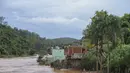 Banjir menutupi jalan perumahan di Raposos, negara bagian Minas Gerais, Brasil, Selasa (11/1/2022). Tanah longsor akibat hujan deras telah menewaskan sedikitnya 12 orang dan pihak berwenang sedang memantau bendungan yang bisa jebol. (AP Photo/Eugenio Savio)