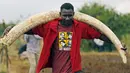 Pekerja membawa gading gajah berukuran besar untuk dibakar di Nairobi National Park, Kenya, (20/4). Sebanyak 105 ton gading gajah berhasil diamankan petugas Kenya Wildlife Service (KWS). (REUTERS / Thomas Mukoya) 