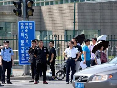 Personel keamanan China berdiri di luar kedutaan besar Amerika Serikat setelah laporan ledakan di Beijing, Kamis (26/7). Ledakan disebut berada dekat tempat warga China mengantre untuk masuk ke Kedubes AS untuk mengurus visa. (AP/Mark Schiefelbein)