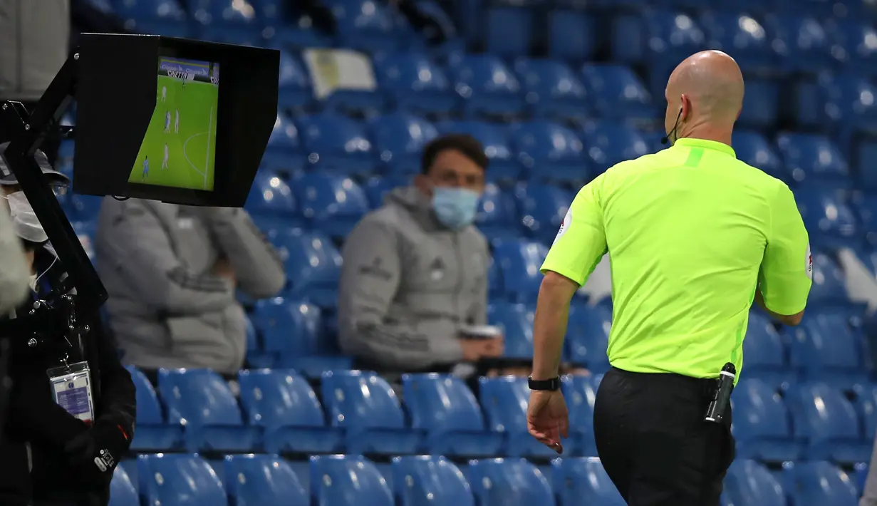 Wasit Anthony Taylor memeriksa VAR yang memutuskan memberi kartu merah kepada gelandang Arsenal, Nicolas Pepe, dalam laga lanjutan Liga Inggris pekan ke-9 di Elland Road Stadium, Leeds, Minggu (22/11/2020). Arsenal bermain imbang 0-0 dengan Leeds United (AFP/Molly Darlington/Pool)