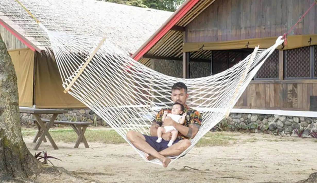 Masih bersama sang ayah, kali ini Salma sedang berada di pelukan sang ayah. Bapak dan anak ini tampak begitu asik menikmati waktu bersamanya sambil  duduk di atas ayunan tali yang dikaitkan ke pohon. (Instagram/riodewanto)
