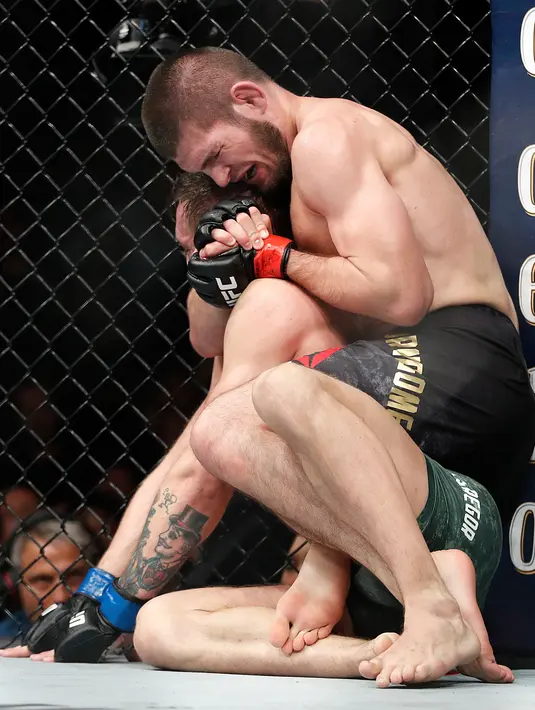 Khabib Nurmagomedov saat mengunci Conor McGregor dalam pertarungan UFC 229 di Las Vegas, AS (6/10). Nurmagomedov dinyatakan menang melalui submission. Dia melakukan rear naked choke kepada McGregor. (AP Photo/John Locher)