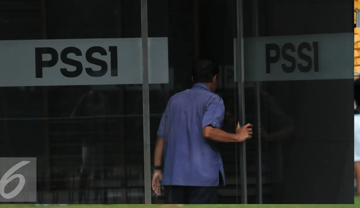 Salah satu karyawan masuk ke dalam kantor PSSI di kawasan Stadion GBK Jakarta, Selasa (19/4/2016). Setahun pasca dibekukan oleh Kemenpora, HUT PSSI ke-86 mengusung tema #We Are PSSI. (Liputan6.com/Helmi Fithriansyah)