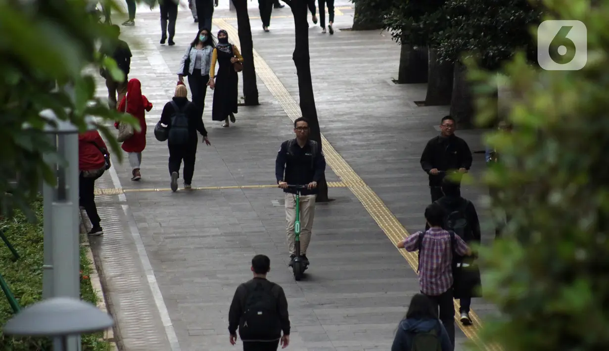 Pengguna otoped listrik Grabwheels melintas di trotoar Jalan Jenderal Sudirman, Jakarta, Kamis (14/11/2019). Pemprov DKI Jakarta melarang penggunaan otoped listrik di trotoar, Jembatan Penyeberangan Orang (JPO) serta pada pelaksanaan Hari Bebas Kendaraan. (Liputan6.com/Helmi Fithriansyah)