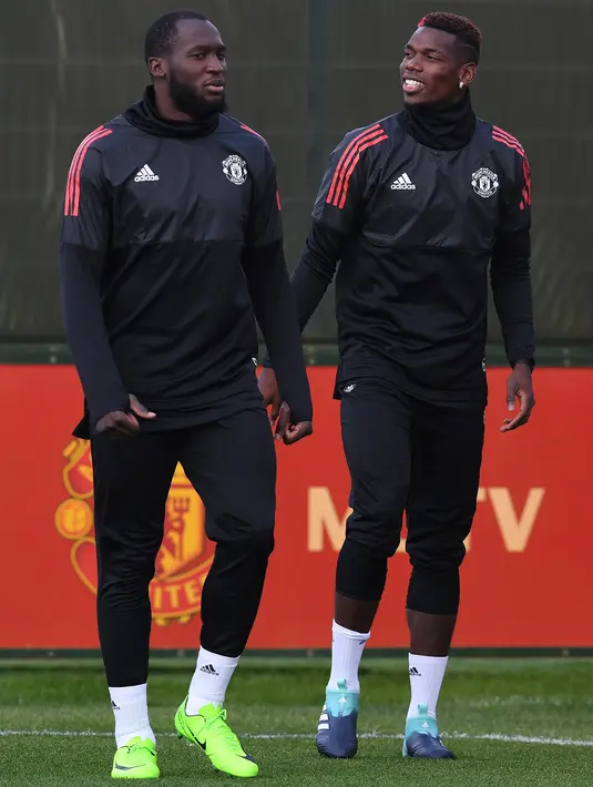 Pemain Manchester United, Romelu Lukaku (kiri) dan Paul Pogba memasuki lapangan tempat latihan di club training complex, Carrington, Manchester, (11/9/2017). MU akan melawan FC Basel di grup A Liga Champions. (AFP/Paul Ellis)