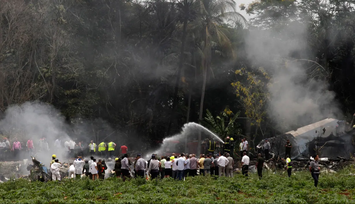 Pemadam kebakaran memadamkan api yang membakar pesawat Boeing 737 yang jatuh di Havana, Kuba, Jumat (18/5). Menurut Presiden Kuba Miguel Diaz, terdapat tiga korban mengalami luka serius di antara 114 penumpang dan awak. (AP Photo/Enrique de la Osa)