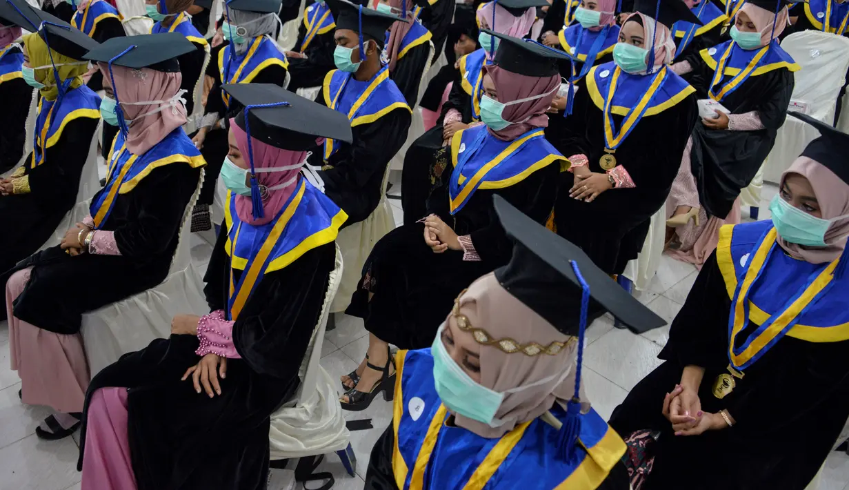 Sejumlah pelajar yang memakai masker sebagai tindakan pencegahan terhadap virus corona COVID-19 mengikuti acara wisuda SMK Farmasi di Banda Aceh (24/9/2020). (AFP/Chaideer Mahyuddin)