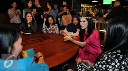 Iis Dahlia tampak berbincang dengan para fansnya saat berbuka puasa bersama di kawasan Senayan, Jakarta, Jumat (10/7/2015). Iis Dahlia tampil cantik dengan busana muslim berwarna pink. (Liputan6.com/Andrian M Tunay)