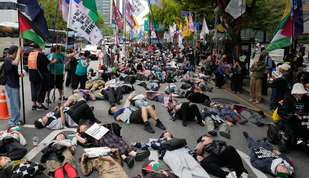 Warga yang menyatakan solidaritas terhadap Palestina berbaring di jalan saat menggelar aksi menentang tindakan militer Amerika Serikat dan Israel di Gaza, di Seoul, Korea Selatan, Sabtu (3/10/2026). Aksi die-in tersebut dilakukan sebagai bentuk simbolis untuk menggambarkan korban konflik di Gaza. Para peserta aksi membawa sejumlah atribut dukungan terhadap Palestina dan menyampaikan tuntutan terkait penghentian serangan serta situasi kemanusiaan di Gaza. (AP Photo/Ahn Young-joon)