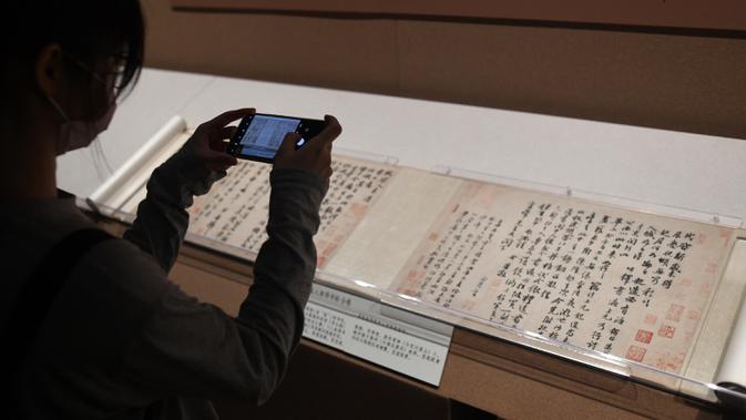 Pengunjung memotret benda saat konferensi pers pameran kaligrafi dan lukisan Su Shi di Museum Istana, Beijing, China, 31 Agustus 2020. Pameran kaligrafi dan lukisan Su Shi akan digelar pada 1 September hingga 30 Oktober. (Xinhua/Jin Liangkuai)