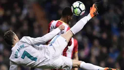 Striker Real Madrid, Cristiano Ronaldo, berebut bola dengan bek Girona, Jonas Ramalho, pada laga La Liga di Stadion Santiago Bernabeu, Senin (19/3/2018). Real Madrid menang 6-3 atas Girona. (AFP/Javier Soriano)