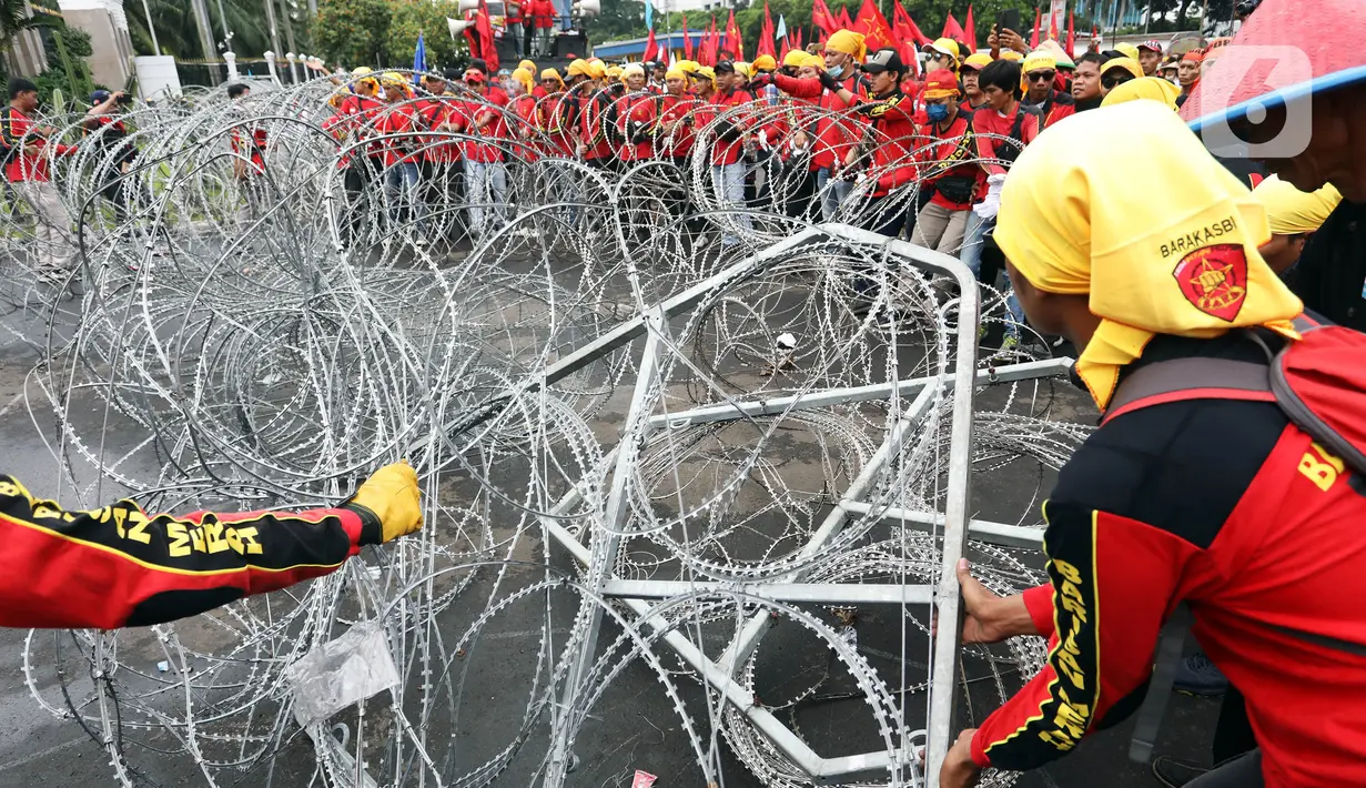 Pengunjuk rasa  menggelar demonstrasi di depan gedung DPR RI, Senayan, Jakarta, Selasa (14/3/2023). Unjuk rasa yang diikuti serikat buruh, mahasiswa, dan petani itu menuntut pemerintah untuk segera mencabut Peraturan Pemerintah Pengganti Undang-Undang (Perppu) Nomor 2 Tahun 2022 tentang Cipta Kerja. (Liputan6.com/Johan Tallo)