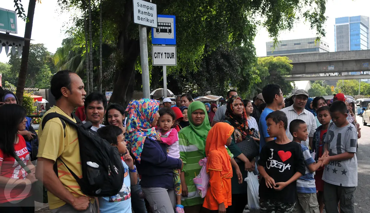Warga menunggu kedatangan Bus City Tour Jakarta di halte Masjid Istiqlal, Jakarta, Sabut (26/12/2015). Sejumlah warga memanfaatkan waktu Libur berkeliling Jakarta dengan Bus City Tour. (Liputan6.com/Yoppy Renato)