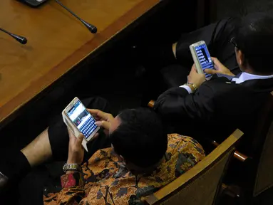 Saat rapat Paripurna sejumlah anggota dewan sibuk dengan ponselnya. Dua orang anggota dewan terlihat sedang mengamati ponselnya saat rapat Paripurna DPR, Jakarta (09/02/2015). (Liputan6.com/Andrian M Tunay)