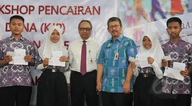 Kepala Dinas Pendidikan Arie Budhiman (kedua kanan) dan Direktur Utama Bank DKI Eko Budiwiyono bersama para siswa-siswi berfoto bersama usai memberikan Kartu Jakarta Pintar (KJP) di SMK 56 Pluit, Jakarta, Kamis (21/5/2015).(Liputan6.com/Herman Zakharia)