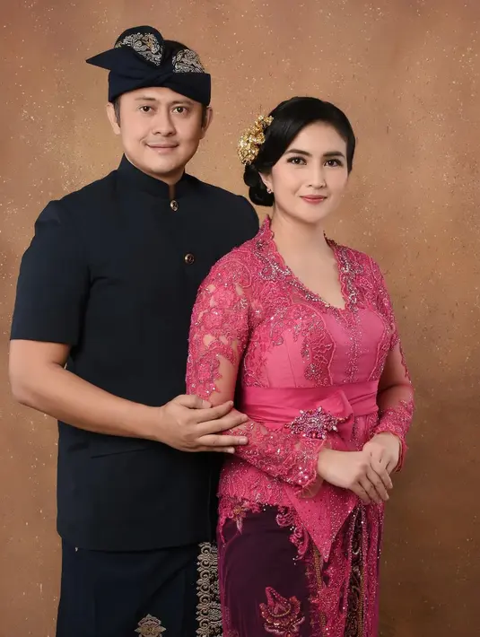 Di foto ini, Kadek Devie berpose bersama sang suami mengenakan kebaya Bali. Kebaya merah muda yang senada dengan seragam Ibu Bhayangkari, dipadu kain Bali merah yang serasi. [Foto: Instagram/kddevie]