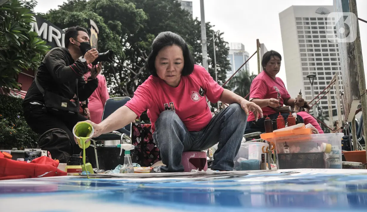Seniman yang tergabung dalam 20 Perempuan Perupa Indonesia saat melukis di kawasan Bundaran HI, Jakarta, Minggu (22/5/2022). Kegiatan melukis bersama dengan tema Harkat tersebut dalam rangka memperingati Hari Kebangkitan Nasional yang nantinya akan dipamerkan di Tugu Kunstkring Paleis Gallery pada 24 Mei mendatang. (merdeka.com/Iqbal S. Nugroho)