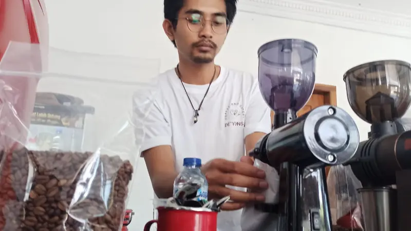 Salah satu barista De'Yons Cafe and Eatery Garut tengah menyajikan kopi Garut bagi pengunjung yang datang. (Liputan6.com/Jayadi Supriadin)