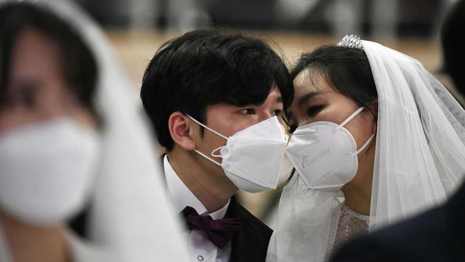 Peserta pernikahan massal di Korea Selatan terpaksa mengenakan masker guna mengantisipasi penyebaran Virus Corona. (Source: AFP)