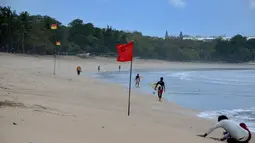 Anak-anak berjalan dengan papan selancar mereka di pantai Kuta di pulau resor Bali (4/10/2021). Setiap tamu kedatangan internasional ada ketentuan dan persyartan yaitu wajib karantina, tes dan kesiapan satuan tugas. (AFP/Sony Tumbelaka)