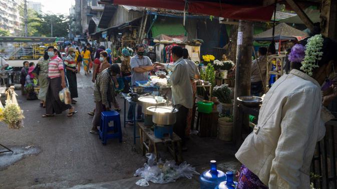 Orang-orang membeli makanan di sebuah pasar sehari setelah militer Myanmar merebut kekuasaan, Yangon, Myanmar, Selasa (2/2/2021). Militer Myanmar menahan pemimpin yang terpilih secara demokratis Aung San Suu Kyi dan memberlakukan keadaan darurat satu tahun. (STR/AFP)