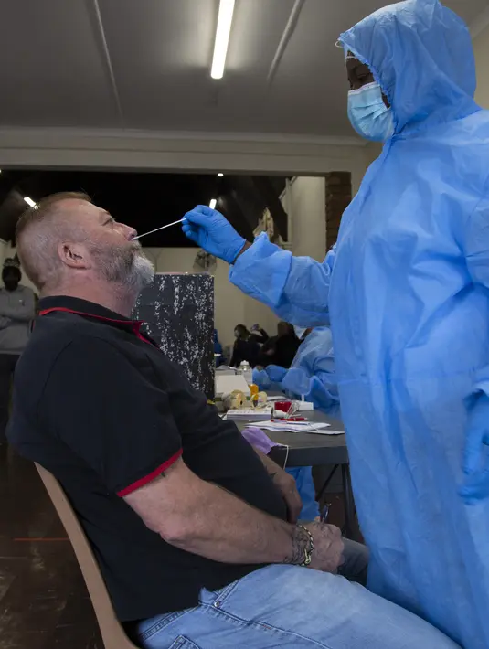Petugas mengambil sampel lendir hidung saat tes usap COVID-19 di sebuah lokasi dekat Johannesburg, Rabu (8/12/2021). Kasus Omicron telah dikonfirmasi setidaknya di sembilan negara Afrika, dengan Afrika Selatan tetap menjadi episenter awal ditemukannya varian baru tersebut. (AP Photo/Denis Farrell)