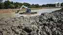 Petugas Sudin SDA Jakarta Timur menggunakan alat berat untuk mengeruk lumpur di Waduk Setu, Cipayung, Jakarta, Rabu (28/7/2021). Pengerukan lumpur ini dilakukan untuk mencegah terjadinya banjir saat musim hujan. (merdeka.com/Iqbal S. Nugroho)