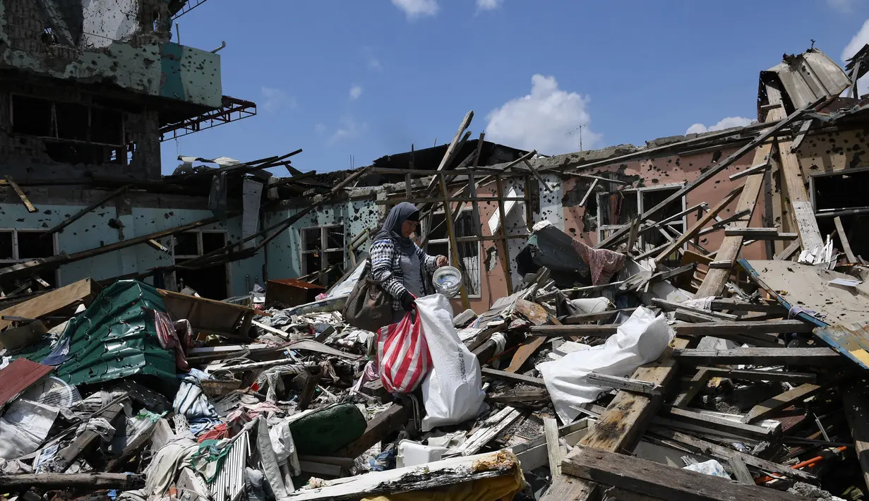 Warga mengumpulkan barang-barang yang bisa diselamatkan saat mengunjungi rumah mereka di Kota Marawi, Mindanao, Filipina, Minggu (1/4). Pertempuran di Kota Marawi menewaskan 1.200 orang. (TED ALJIBE/AFP)