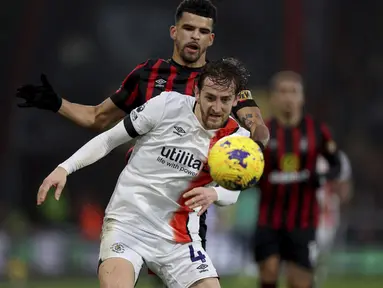 Bek Luton Town, Tom Lockyer berebut bola dengan penyerang Bournemouth, Dominic Solanke pada pekan ke-17 Premier League 2023/2024 di Vitality Stadium, Sabtu (16/12/2023). (Steven Paston/PA via AP)