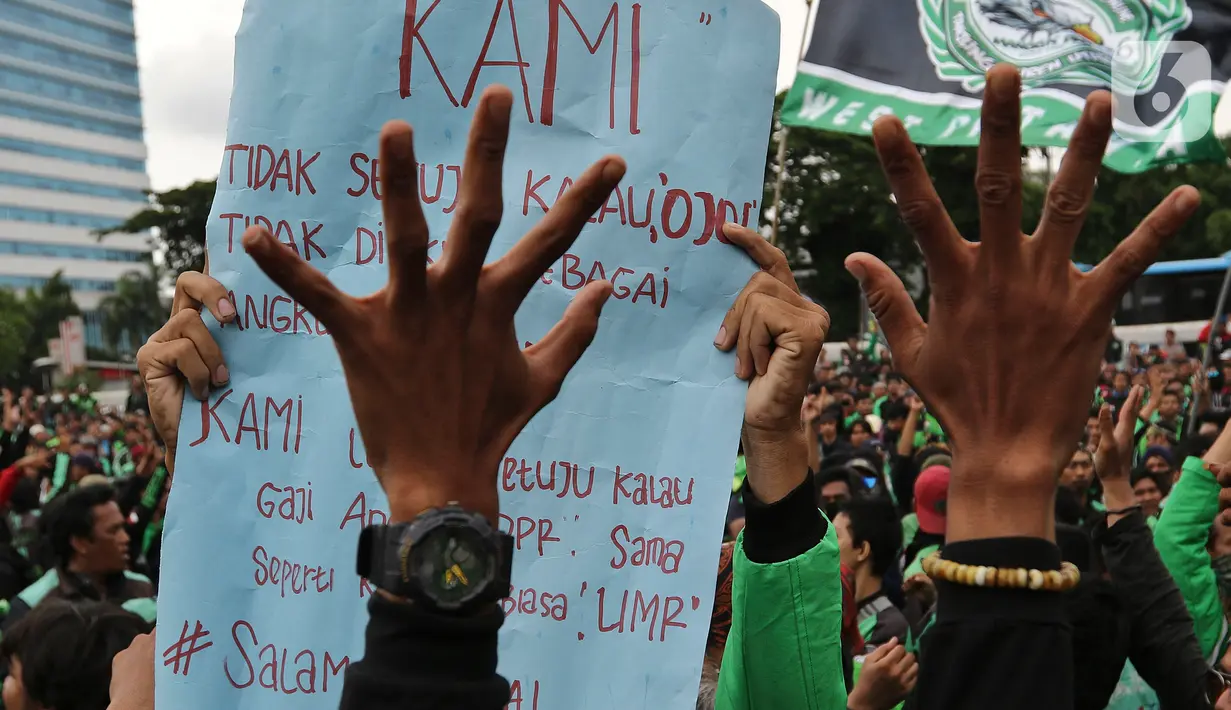 Pengemudi ojek online (ojol) membawa poster saat berdemonstrasi di depan Gedung DPR/MPR, Senayan, Jakarta, Jumat (28/2/2020). Mereka menyampaikan tuntutan terkait UU No 22/2009 itu direvisi dan menjadikan kendaraan roda dua sebagai transportasi khusus terbatas. (Liputan6.com/Johan Tallo)