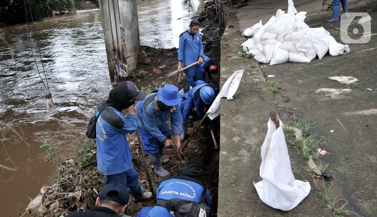 Pekerja Sudin Sumber Daya Air Jakpus menyelesaikan penutupan lubang rembesan di Tanggul Kanal Banjir Barat, Latuharhari, Minggu (5/1/2020). Penutupan untuk mengantisipasi tanggul jebol setelah diketahui terdapat rembesan di sejumlah titik akibat debit air KBB meningkat. (merdeka.com/Iqbal Nugroho)