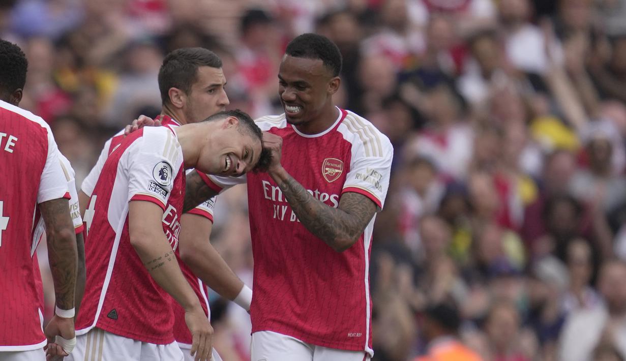 Pemain Arsenal, Gabriel Magalhaes (kanan) menjambak rambut rekan satu timnya, Granit Xhaka setelah dirinya melakukan selebrasi mencetak gol ke gawang Wolverhampton Wanderers dalam laga pamungkas English Premier league 2022/2023 yang berlangsung di Emirates Stadium, Minggu (28/5/2023). (AP Photo/Kin Cheung)
