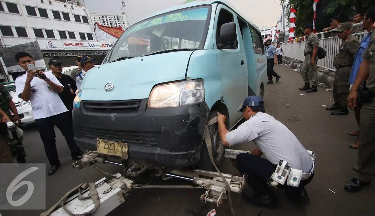 Petugas menertibkan angkot yang mengetem sembarangan di kawasan wisata Kota Tua, Jakarta, Rabu (24/8). Penertiban dilakukan guna membenahi PKL dan parkir liar yang kerap menimbulkan kesewrautan di lokasi tersebut. (Liputan6.com/Immanuel Antonius)