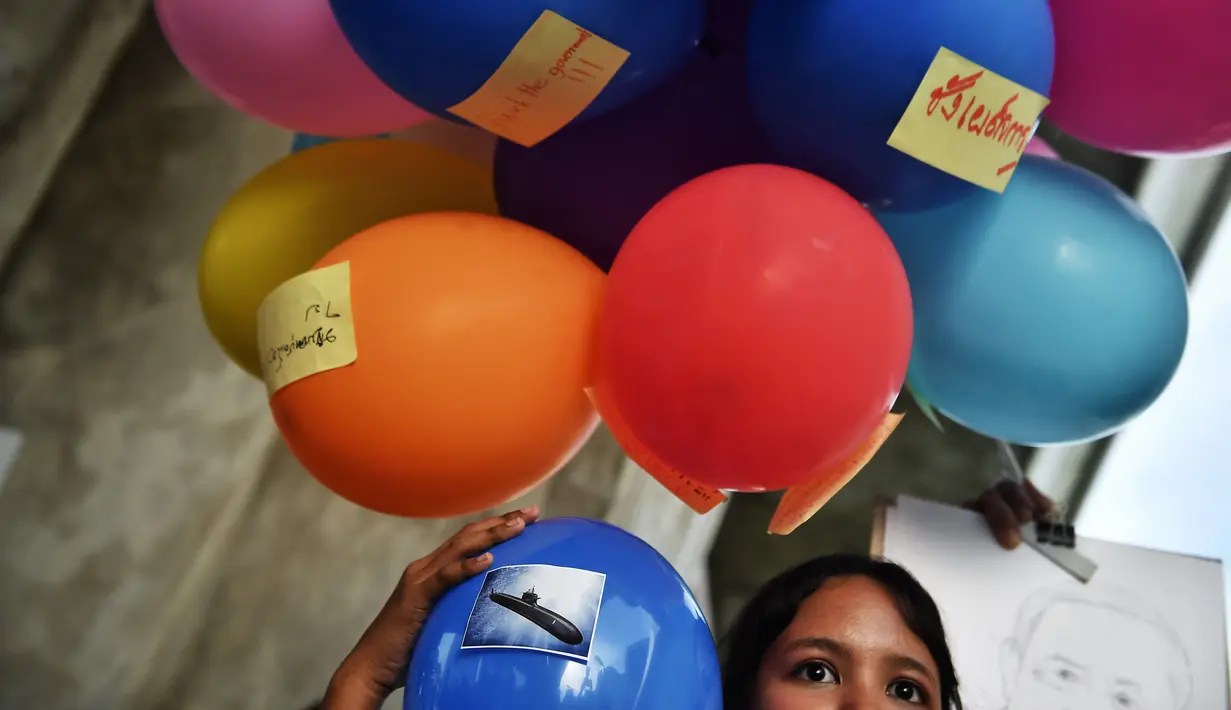 Seorang mahasiswa pengunjuk rasa memegang balon selama demonstrasi menentang pembelian kapal selam oleh pemerintah yang berpihak pada militer di Bangkok (31/8/2020). (AFP/Lillian Suwanrumpha)