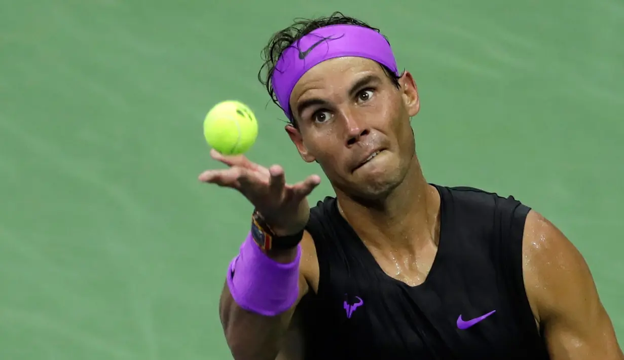 Petenis Spanyol, Rafael Nadal bersiap melakukan servis ke arah lawannya petenis Argentina, Diego Schwartzman  pada babak perempat final AS Terbuka 2019  di Arthur Ashe Stadium, Rabu (4/9/2019). Nadal berhasil melangkah ke semifinal dalam pertarungan tiga set dengan skor 6-4, 7-5, dan 6-2. (AP/Adam H