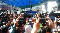 Mobil jenazah dan rombongan keluarga terpidana mati Freddy Budiman ditunggu warga di sepanjang jalan kawasan Krembangan Baru, Surabaya, Jawa Timur. (Liputan6.com/Dhimas Prasaja)