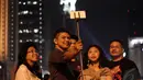 Sejumlah warga mengambil foto selfie saat akan merayakan malam pergantian tahun di kawasan Bundaran HI, Jakarta, Rabu (31/12/2014). (Liputan6.com/Faizal Fanani)