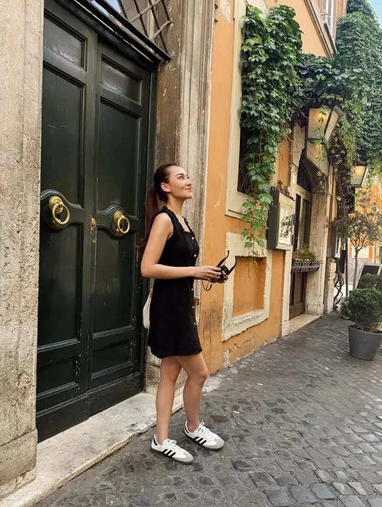 Di sini, Aaliyah tampil chic walau dengan mini dress berwarna hitam, tanpa lengan. Dress ini memiliki detail kancing hingga ke bawah. [Foto: Instagram/aaliyah.massaid]