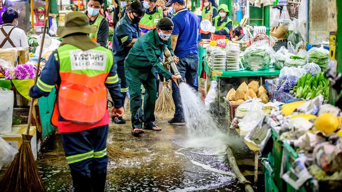 Pekerja Otoritas Metropolitan Bangkok menyapu membersihkan dan mendisinfeksi Pasar Bunga Yodpiman di Bangkok (6/1/2021). Lebih dari 4.000 infeksi tersebut telah dilaporkan sejak pertengahan Desember, ketika klaster virus baru pertama kali terdeteksi di antara pekerja migran.  (AFP/Mladen Antonov)
