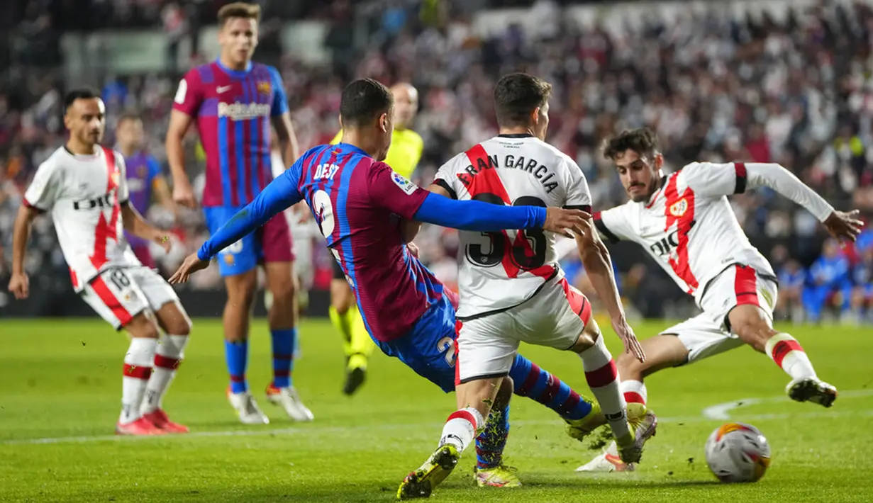 Pemain Barcelona Sergino Dest (kiri) melakukan tembakan ke gawang di depan pemain Rayo Vallecano Fran Garcia pada pertandingan La Liga Spanyol di Stadion Vallecas, Madrid, Spanyol, 27 Oktober 2021. Barcelona kalah 0-1. (AP Photo/Manu Fernandez)