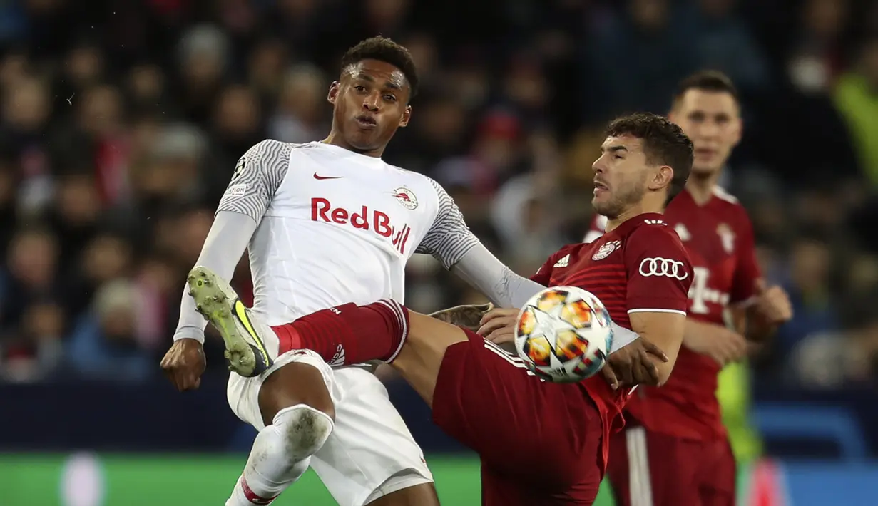 Penyerang RB Salzburg Chukwubuike Adamu berebut bola dengan bek Bayern Munchen Lucas Hernandez dalam leg pertama 16 besar Liga Champions di Red Bull Arena, Kamis dini hari WIB (17/2/2022). Bayern Munchen meraih hasil imbang 1-1 saat bertandang ke markas RB Salzburg. (AP Photo/Alexandra Beier)