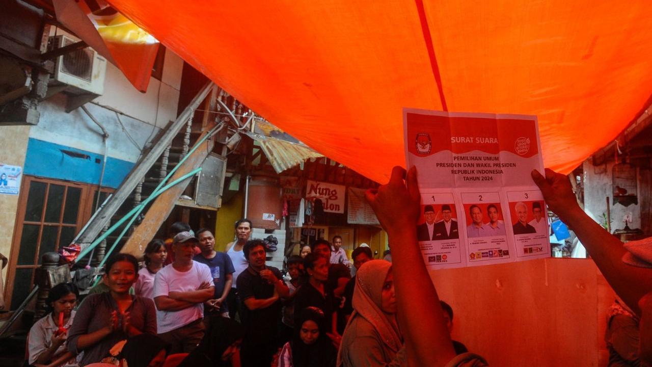 Warga menyaksikan  penghitungan suara Pemilu 2024 yang berlangsung di TPS 56, Kebun Melati, Tanah Abang, Rabu (14/02/2024).  Penghitungan suara di kawasan ini didominasi para pemilih 01. Foto: merdeka.com / arie basuki<br>