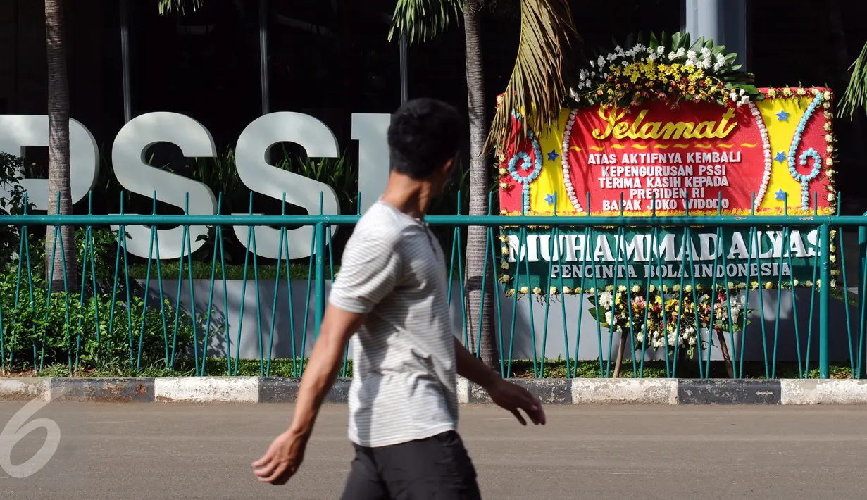 Pejalan kaki melintas di depan kantor PSSI di kawasan Stadion Gelora Bung Karno, Jakarta, Sabtu (27/2/2016). Seseorang mengatasnamakan pecinta sepak bola mengirimi ucapan selamat kepada PSSI. (Liputan6.com/Helmi Fithriansyah)