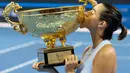 Petenis Prancis, Caroline Garcia mencium trofi yang diraihnya usai mengalahkan petenis nomor satu dunia Simona Halep pada final China Terbuka di Beijing, Minggu (8/10). Garcia, menjadi juara dengan mengalahkan Simona Halep 6-4, 7-6. (AP/Ng Han Guan)